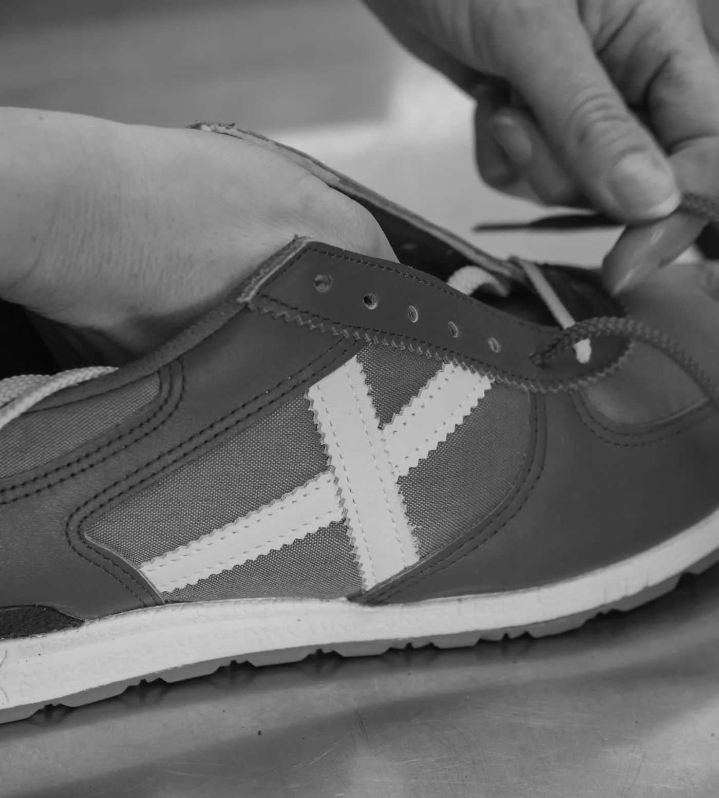 Close-up of a Munich sneaker being laced by hand